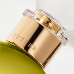 Detail of the top of the 100 ml bottle, with transparent glass and greenish perfum. Spherical cap with gold band. Apollo Hyacinth, a fragrance by Eric Butherbaugh.