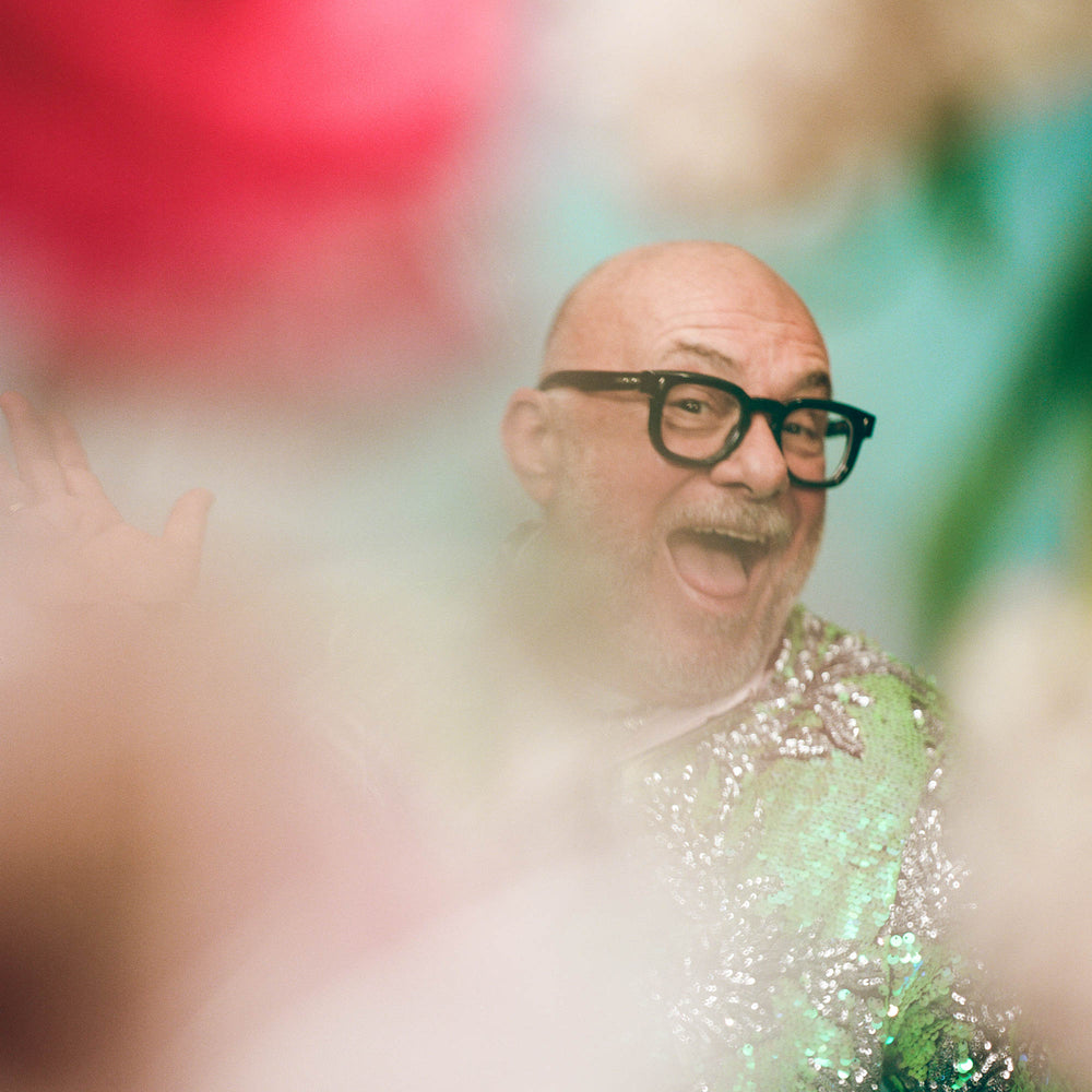 Eric Buterbaugh smiling among unfocused flowers.